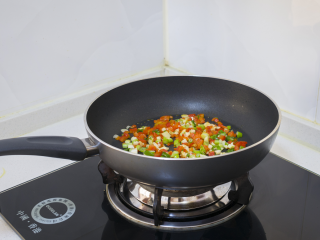 2种藕丁做法简单又快手,锅里倒入红椒、蒜和香葱爆香