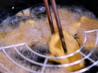 锅包肉是百吃不厌的东北情怀!,煎炸至表面金黄捞出，等油温再次拉高，复炸定型