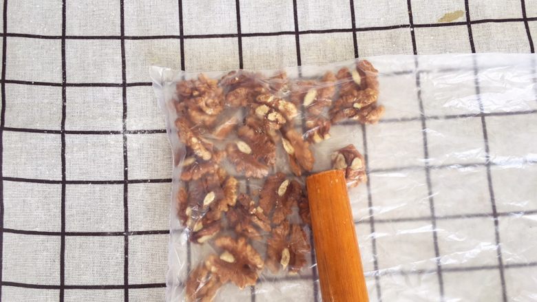 辅食24M➕：核桃酥,烤好的核桃放凉，装进密封袋，用擀面杖擀碎放在一旁备用