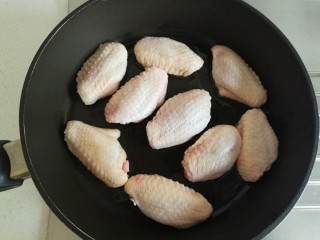 照烧柠檬鸡翅,热锅倒入适量食用油，油温升高后逐个加入鸡中翅。