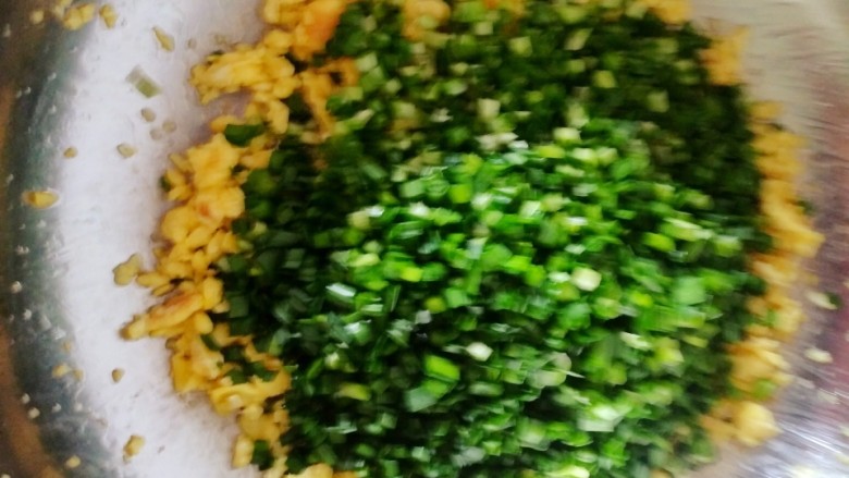 韭菜鸡蛋饺子,把切好的韭菜放入煎熟的鸡蛋上