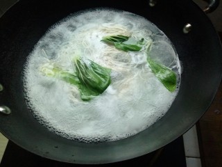热气腾腾的阳春面,面条煮至快熟时，放入青菜。