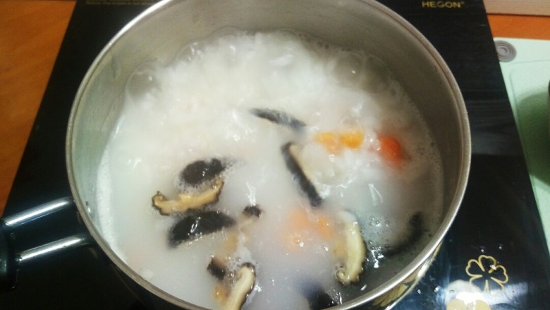 #宝宝辅食#鳕鱼胡萝卜香菇粥,8.待粥熬到差不多的时候,加入香菇,胡萝卜。