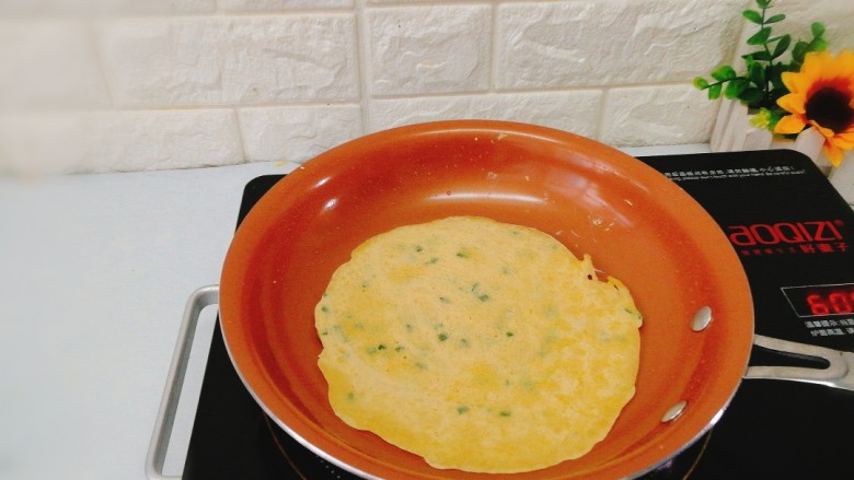 快手早餐+葱花鸡蛋饼,看见四周边上微微翘起，表面已经凝固，就可以煎另一面了。