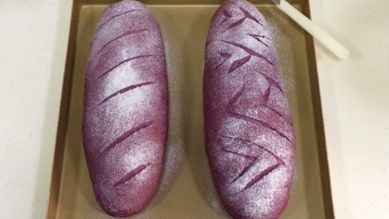 紫薯麻薯夹心软欧,发至两倍大时取出面包，在表面筛一层薄薄的<a style='color:red;display:inline-block;' href='/shicai/ 550'>高筋面粉</a>，用锋利的刀片在面包表面刮出纹理。