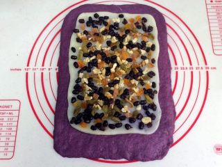 紫薯麻薯夹心软欧,把擀开的麻薯片铺在面片上，把核桃仁、葡萄干、杏干和蜜豆均匀铺在麻薯上，轻轻按压下。