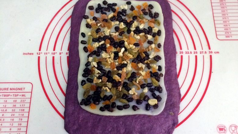 紫薯麻薯夹心软欧,把擀开的麻薯片铺在面片上，把核桃仁、葡萄干、杏干和蜜豆均匀铺在麻薯上，轻轻按压下。