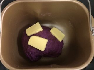紫薯麻薯夹心软欧,待面包揉至15～20分钟，面团成型，加入黄油继续揉面。
