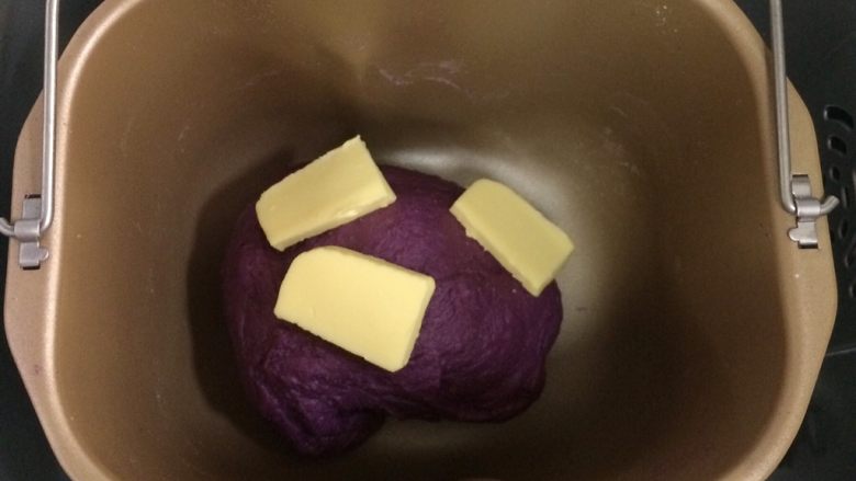 紫薯麻薯夹心软欧,待面包揉至15～20分钟，面团成型，加入黄油继续揉面。
