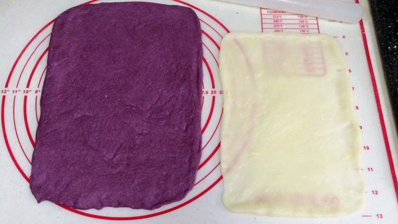 紫薯麻薯夹心软欧,取一份松弛好的面团，用手拍扁，用擀面杖把面团擀开，翻面再擀会，用手整理成长方形，压薄底边。取一份麻薯，继续用擀面杖擀成比面片小点的长方形。