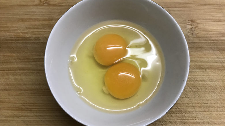 酸黄瓜蛋炒饭,鸡蛋打入碗中。