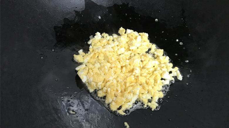 酸黄瓜蛋炒饭,用勺子快速把鸡蛋液划散，稍凝固后盛出。