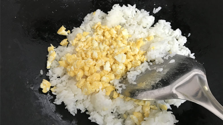 酸黄瓜蛋炒饭,把炒好的鸡蛋倒入米饭中。