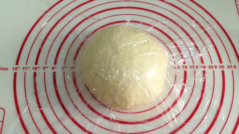 红糖肉桂面包卷,将面团取出排气滚圆，盖好保鲜膜松弛15分钟。