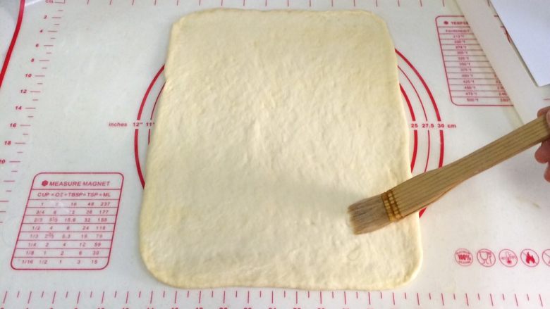 红糖肉桂面包卷,用刷子均匀的刷一点清水，上端留出约1-1.5厘米。