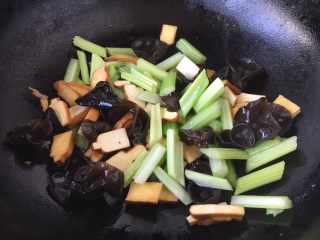 #菌类料理# 黑木耳炒芹菜,当花椒油油温6或者7成热时，放入木耳、芹菜段、香干，翻炒均匀。