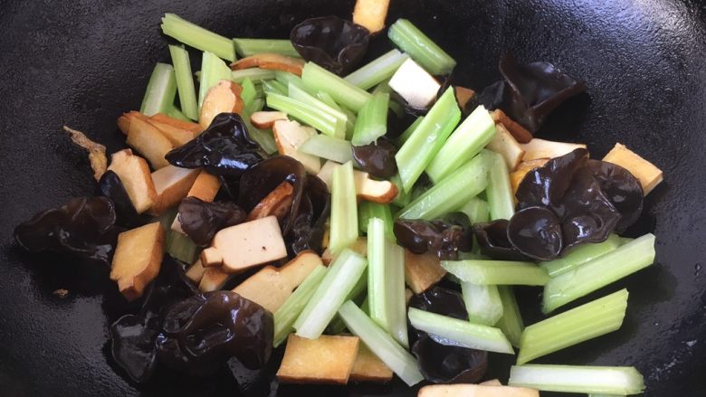 #菌类料理# 黑木耳炒芹菜,当花椒油油温6或者7成热时，放入木耳、芹菜段、香干，翻炒均匀。