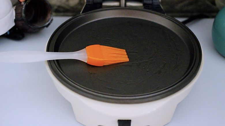 清新蕾丝蛋卷,多功能华夫机提前预热后、用硅胶刷蘸少许花生油抹匀锅盘