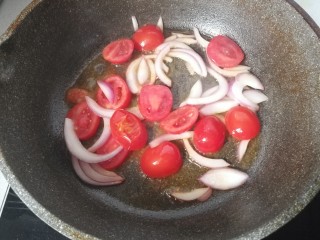 番茄火腿炒意面,锅中放少许油，下入小番茄和洋葱丝煸炒几下