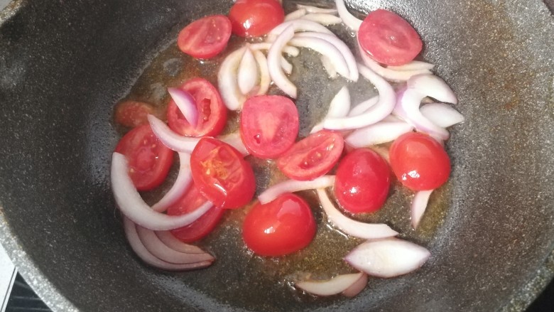 番茄火腿炒意面,锅中放少许油，下入小番茄和洋葱丝煸炒几下