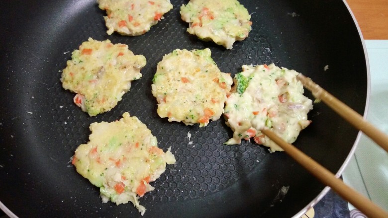 鳕鱼时蔬煎饼,10.平底锅刷一层油,加热后舀入一勺面糊,用勺子压成圆饼状。
