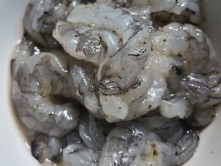 芦笋炒虾仁,基尾虾去壳取虾线，沥干水。加胡椒粉、盐、料酒、鸡蛋清搅拌均匀腌制。