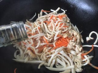 #菌类料理# 蚝油鸡丝杏鲍菇,沿锅沿烹入1勺的料酒。