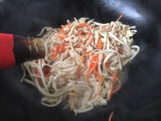 #菌类料理# 蚝油鸡丝杏鲍菇,倒入2勺的蚝油，1勺的生抽，翻炒均匀。