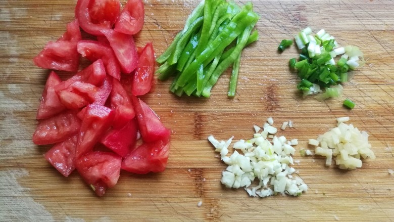 家常炒茄丝,将西红柿切块，尖椒切丝，葱姜蒜切未备用。