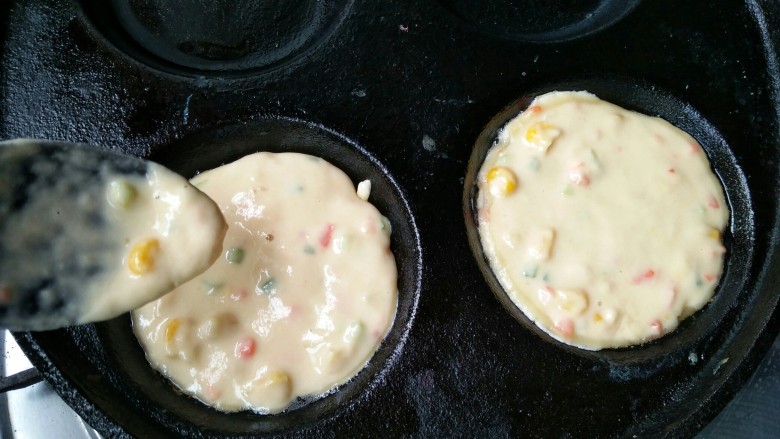 什锦蛋黄堡,在蛋饺锅的两个孔中舀进一勺粉糊。