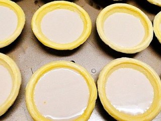 自制零食+迷你原味蛋挞,将过筛的挞水加入到蛋挞皮中，8分满即可，如图，预热烤箱150度，5分钟