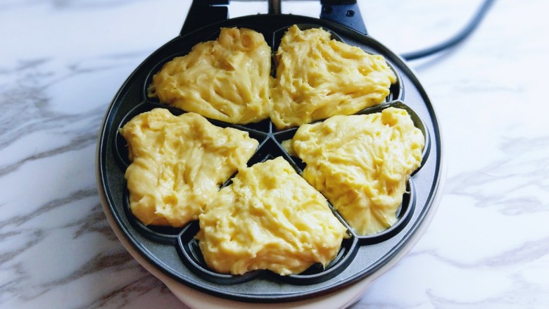 #辅食计划#华夫饼～酵母版,这时面糊也发酵好了，用勺子盛一勺倒在烤盘模具中。