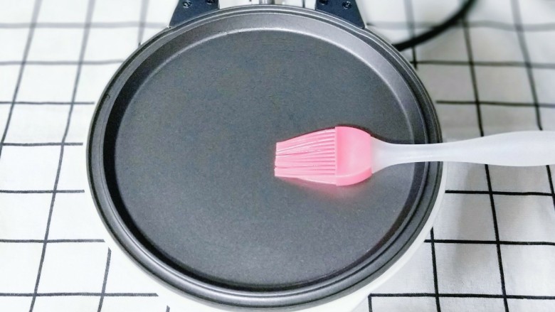 网红蕾丝蛋卷#华夫饼机器版#,刷上少许食用油，将华夫饼机器接上电源，预热2分钟。