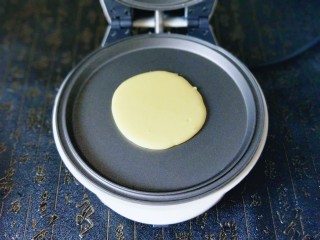 辅食计划&铜锣烧#华夫饼机器版#,盛一勺静置好的面糊，从上而下倒入烤盘中间，面糊自然成圆形。