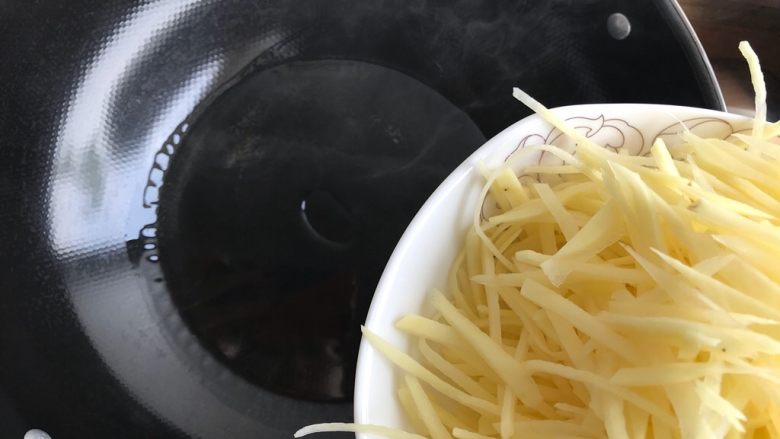 蒜香酸辣土豆丝,开最大火，待锅内油冒烟的时候，倒入土豆丝