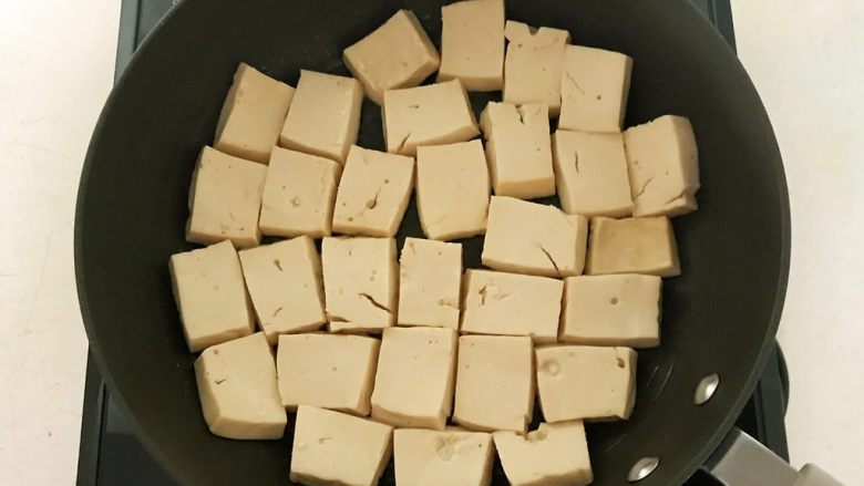 芝香千页豆腐,炒锅烧5分热的时候放入千页豆腐，全程小火煎制