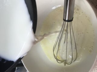 爆浆海盐奶盖蛋糕,加入好的牛奶缓慢倒入蛋黄液中，一边倒一边搅拌均匀