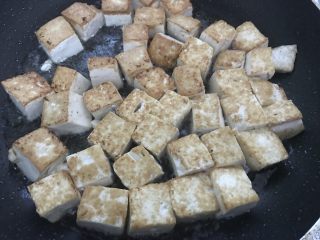 做道小朋友也爱吃的酸甜豆腐,一面煎至金黄色翻面，两面都煎金黄时，洒入盐拌匀。