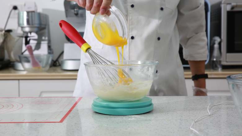 爆浆海盐奶盖蛋糕,加入蛋黄搅拌均匀，如果有颗粒，用刮刀摁压即可