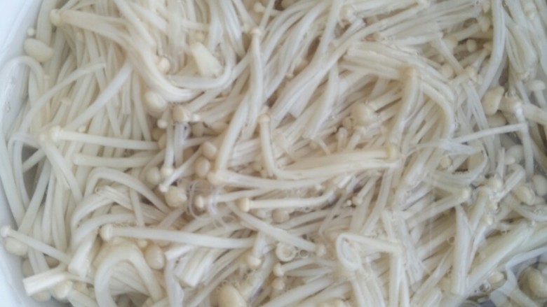 菌类料理――凉拌三丝,将煮好的金针菇放入备好的凉开水中。