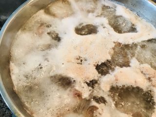 红焖羊肉,坐锅把剁好的羊肉放入凉水中烧开 撇去浮末