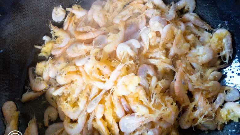 鲜韭炒河虾,将腌好的河虾放入锅中翻炒至金黄色后捞出备用