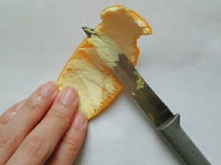 糖渍橙皮,去掉橙皮里面的白色部分，至露出麻点。可以像这样先斜刀片，再刮，也可以用刮皮器直接刮下外皮。