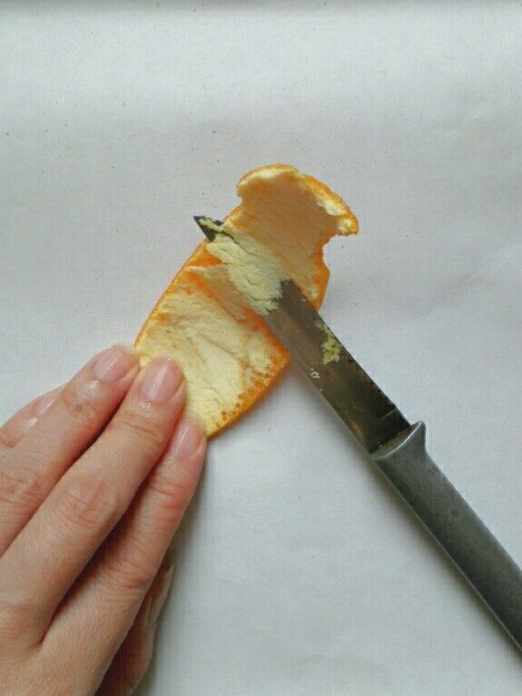 糖渍橙皮,去掉橙皮里面的白色部分，至露出麻点。可以像这样先斜刀片，再刮，也可以用刮皮器直接刮下外皮。