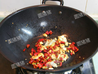 红亮诱人——麻辣鸡翅,再放入切碎的红椒，花椒炒出香味。