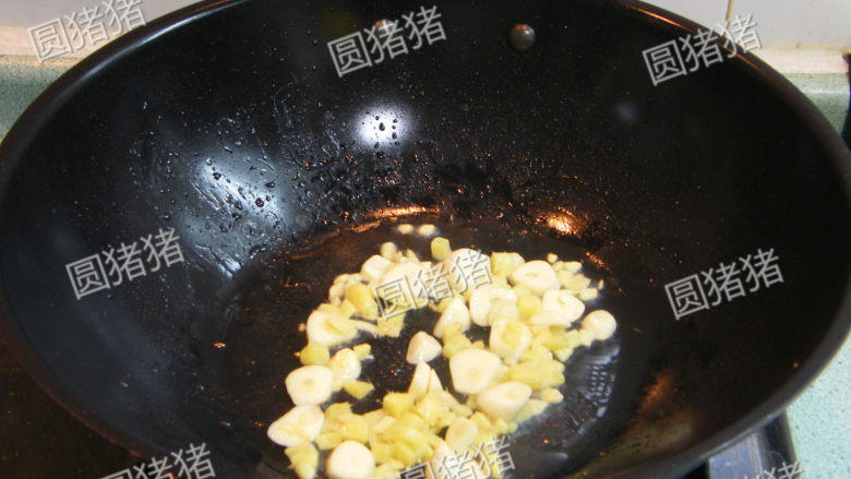 红亮诱人——麻辣鸡翅,锅内放入姜片，蒜片爆炒出香味。