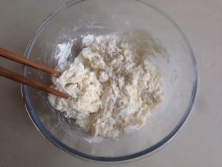 “甜甜圈”馒头,将酵母水倒入面粉里，用筷子拌成絮状。