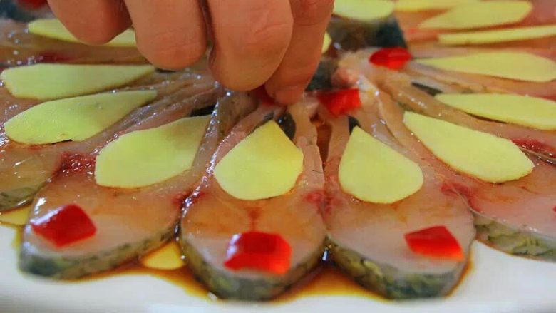 孔雀开屏（武昌鱼版）,把切好的姜片红椒按孔雀开屏的形状摆在前面摆好的鱼肉上