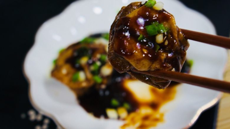 上海菜，油面筋塞肉,筷子夹起一只咬一口