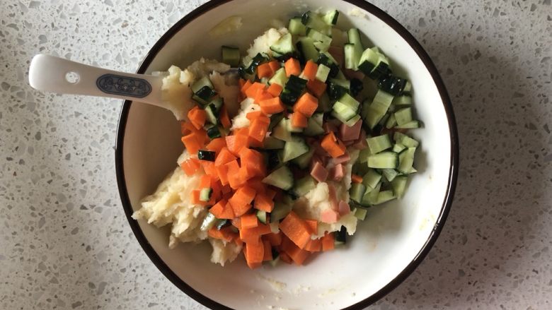 时蔬土豆泥沙拉,搅拌均匀以后，加入胡萝卜丁、黄瓜丁、火腿肠丁